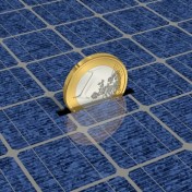 Eurostück verschwindet im Schlitz von Solarpanels